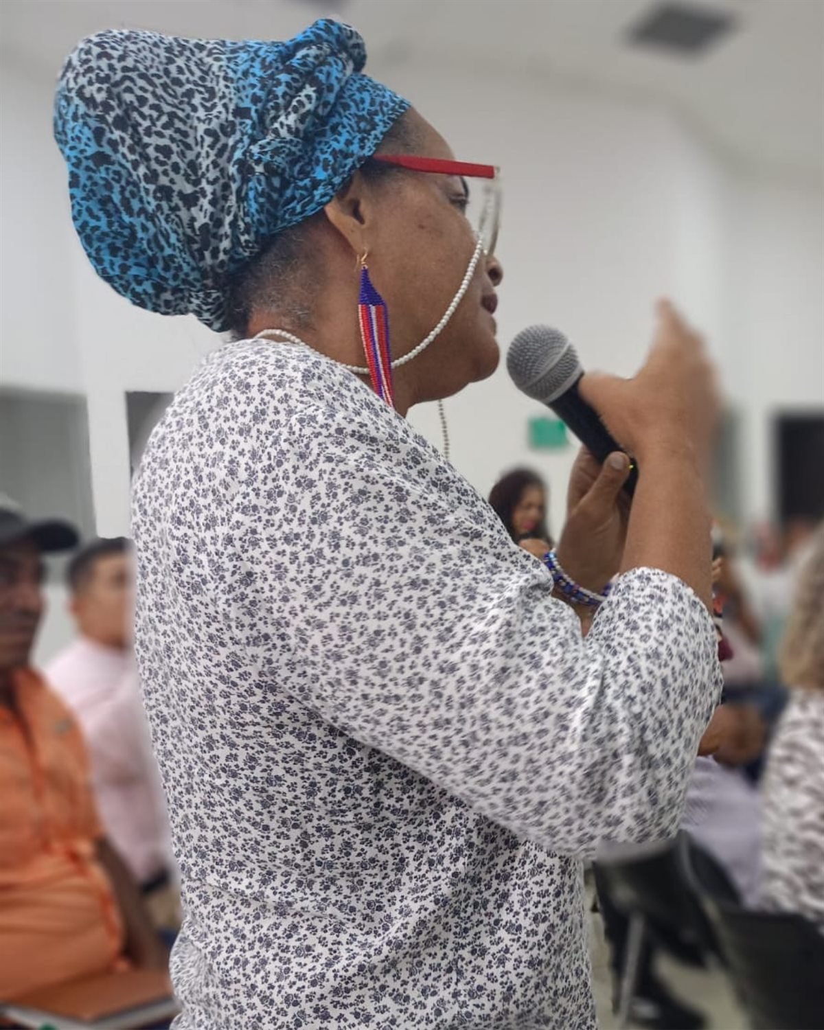 Lideresa de la Fundación dirigiéndose a la comunidad con micrófono en un encuentro en Galapa