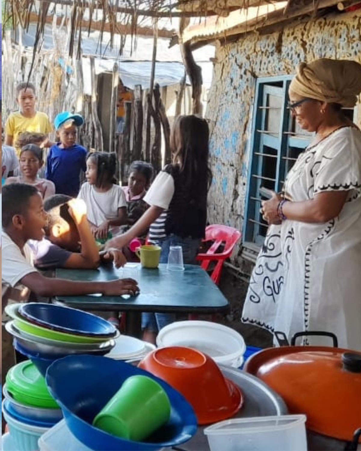 Niñas y niños reunidos alrededor de una mesa en un espacio comunitario del territorio